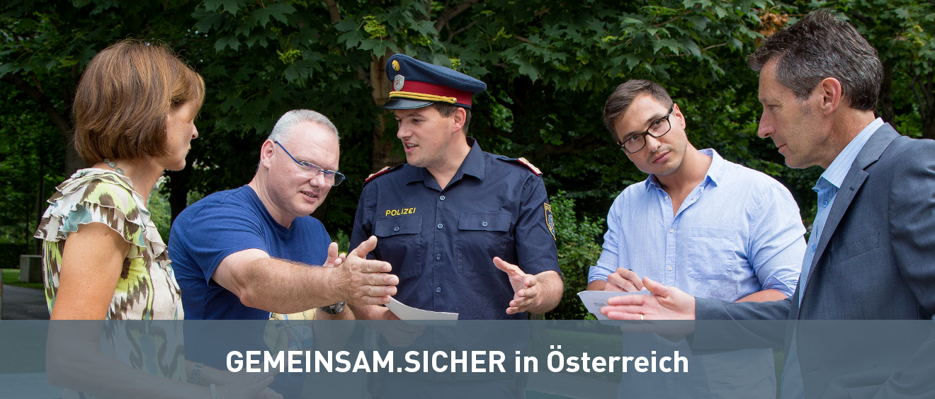 Polizist mit Sicherheitsbeauftragten und BürgerInnen