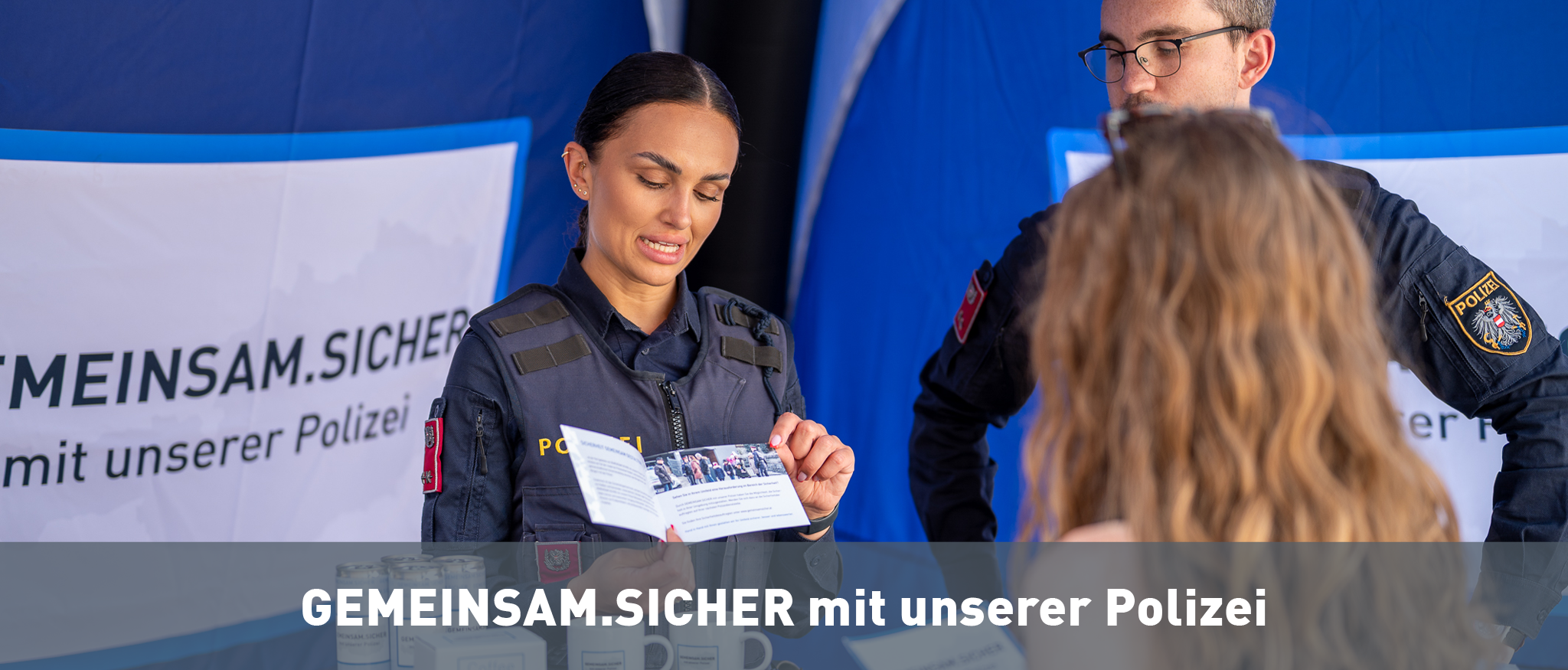 Polizistin und Polizist mit Bürgerin